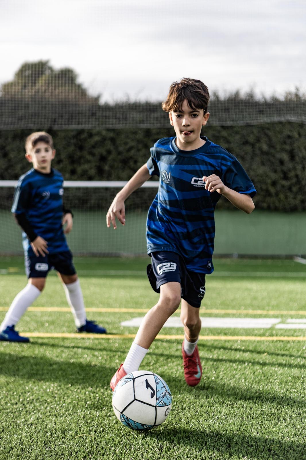 Niño de la escuela de fútbol con la equipación del club