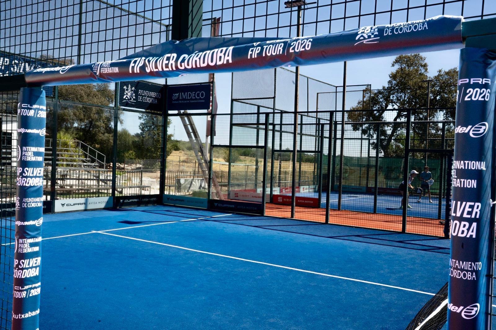 Pistas de pádel azules del club con la bandera del torneo FIP